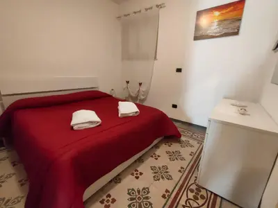 a bedroom with a red bed with two towels on it at Casa Lia al centro di palermo in Palermo