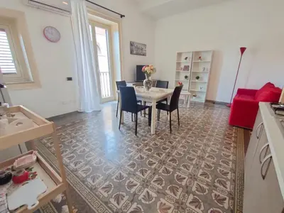 a living room with a dining room table and chairs at Casa Lia al centro di palermo in Palermo