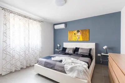 a bedroom with a large bed with blue walls at Villa Sikania Seaview Scopello in Castellammare del Golfo