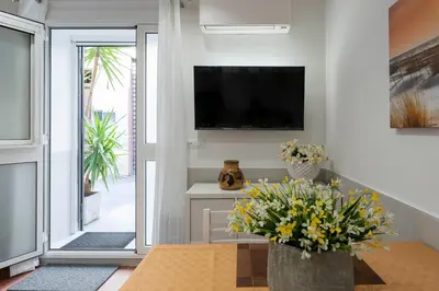 a living room with a table and a tv and flowers at OLIVUZZA TOWER in Palermo