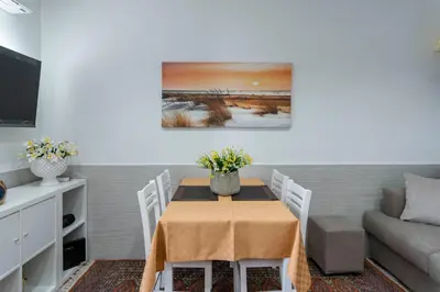 a dining room with a table and a couch at OLIVUZZA TOWER in Palermo