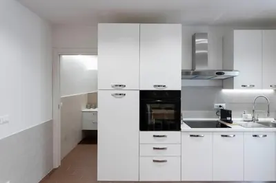 a white kitchen with white cabinets and a sink at OLIVUZZA TOWER in Palermo