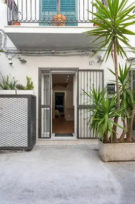 a house with a palm tree in front of a building at OLIVUZZA TOWER in Palermo
