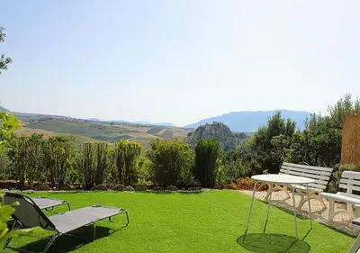 a lawn with two chairs and a table on it at Villa Finestra sul Castello in Partinico