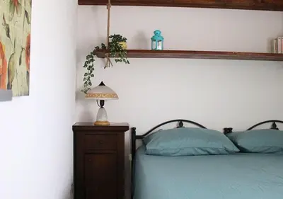 a bedroom with a bed and a lamp on a night stand at Villa Finestra sul Castello in Partinico