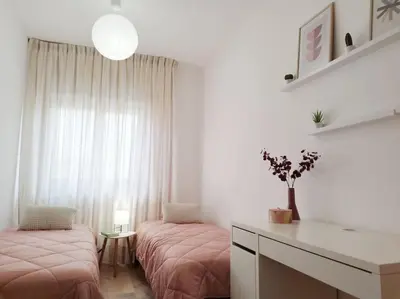 a bedroom with two beds with pink sheets and a window at Casa Phimes in Calatafimi