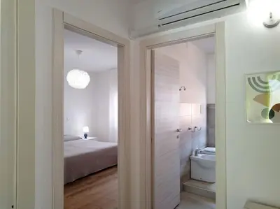 a bedroom with a bed and a door leading to a bathroom at Casa Phimes in Calatafimi