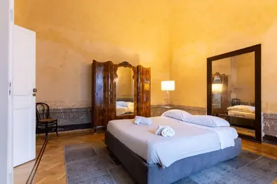 a bedroom with a bed and a large mirror at Appartamento Al Genio in Palermo