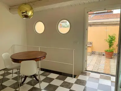 a dining room with a table and two windows at Appartamento Al Genio in Palermo