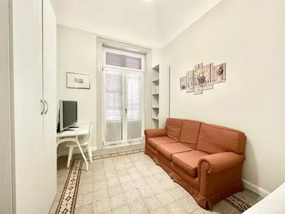 a living room with a couch and a desk at PALAZZO LA ZAGARA in Palermo