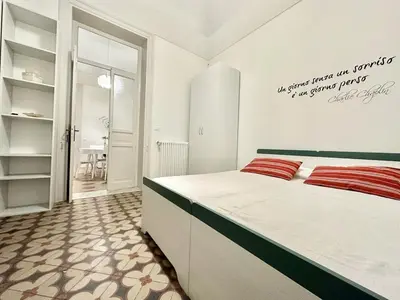 a bedroom with a large bed with red pillows at PALAZZO LA ZAGARA in Palermo