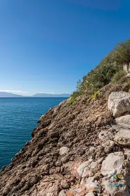 a rocky mountain with graffiti on it next to the water at Villa Giacona Venuti in Terrasini