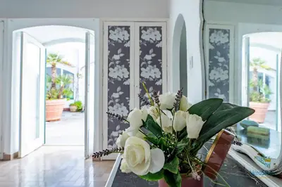 a vase with white flowers on a table in a room at Villa Giacona Venuti in Terrasini