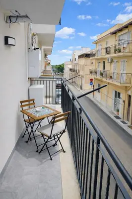 a balcony with a table and chairs on a building at Casa Ventitré in Balestrate