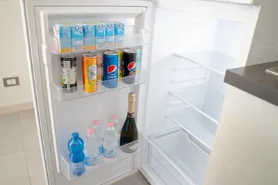 an open refrigerator with a bottle of wine and drinks at City Life in Palermo