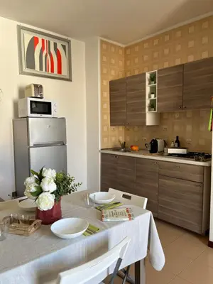 a kitchen with a table with plates and flowers on it at Casa Conturrana,10 metri dalla spiaggia di San Vito in San Vito lo Capo