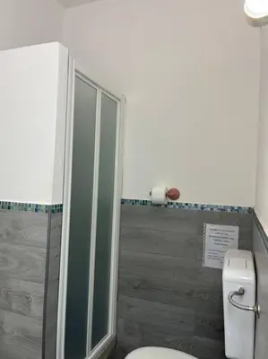 a bathroom with a toilet and a glass shower at Casa Conturrana,10 metri dalla spiaggia di San Vito in San Vito lo Capo