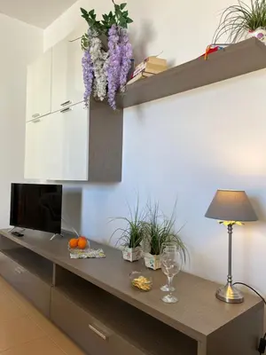 a living room with a table with a lamp and flowers at Casa Conturrana,10 metri dalla spiaggia di San Vito in San Vito lo Capo