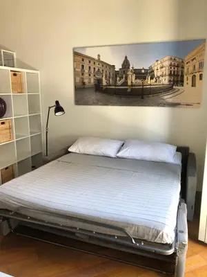 a bedroom with a bed with a picture on the wall at Siandri House in Palermo