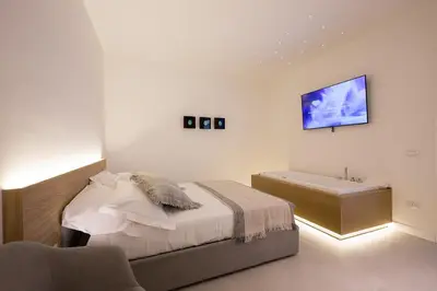 a white bedroom with a bed and a bath tub at Giada Luxury Terrasini in Terrasini