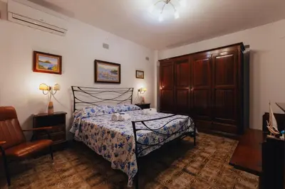 a bedroom with a bed with a blue and white comforter at Monia beach house in Santa Flavia