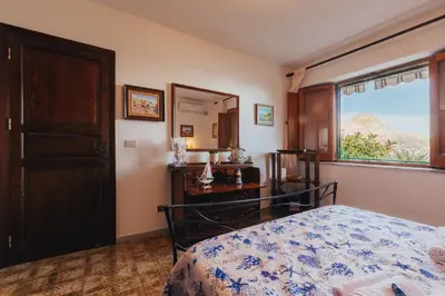 a bedroom with a bed and a dresser and a window at Monia beach house in Santa Flavia