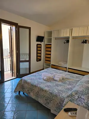a bedroom with a large bed and a balcony at Casa Dalila in San Vito lo Capo