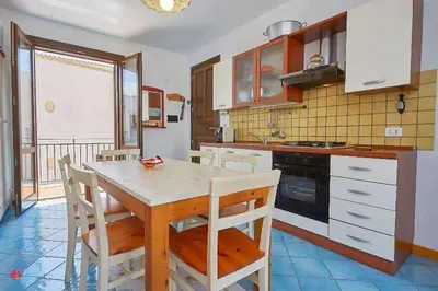 a kitchen with a table and chairs in a kitchen at Casa Dalila in San Vito lo Capo