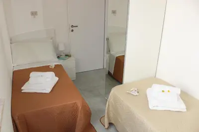 a room with a bed and a mirror with towels at Villa Nàmali just 100 meters from the sea !!! in Trappeto