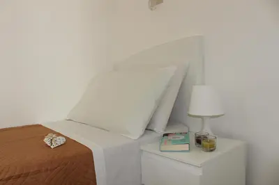 a bedroom with a bed and a nightstand with a lamp at Villa Nàmali just 100 meters from the sea !!! in Trappeto