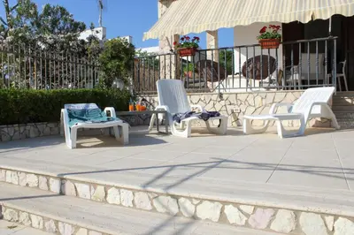 a group of white chairs sitting on a patio at Villa Nàmali just 100 meters from the sea !!! in Trappeto