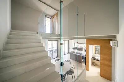 a glass staircase in a house with a table and chairs at Villa vista mare Piscina e SPA in Castellammare del Golfo