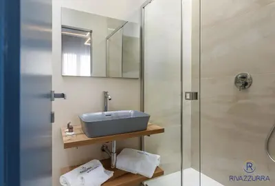 a bathroom with a sink and a glass shower at Rivazzurra Beach Rooms in San Vito lo Capo