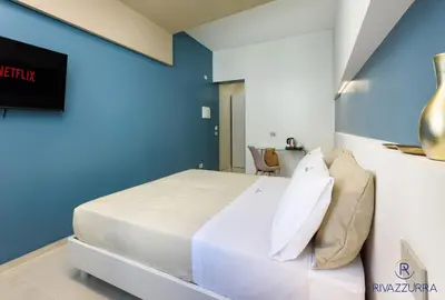 a bedroom with a bed and a blue wall at Rivazzurra Beach Rooms in San Vito lo Capo