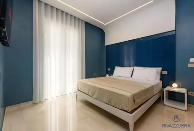 a bedroom with blue walls and a large bed at Rivazzurra Beach Rooms in San Vito lo Capo