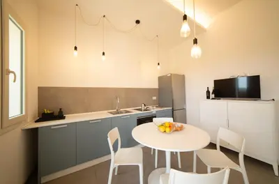 a kitchen and dining room with a table and chairs at Blu Home Scopello in Castellammare del Golfo