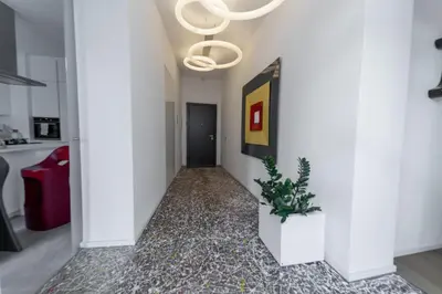 a hallway with white walls and a chandelier at Casa Slide a Palermo in Palermo