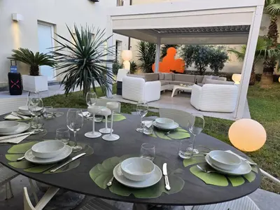 a table with plates and wine glasses on a patio at Casa Slide a Palermo in Palermo