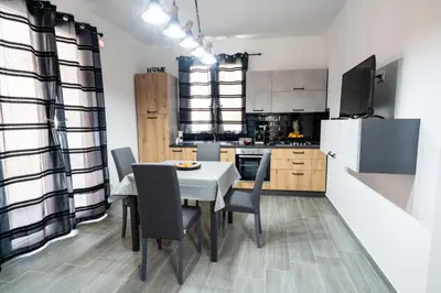 a kitchen with a table and chairs and a refrigerator at AVA VACATION HOME in Borgetto
