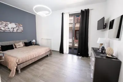 a bedroom with a bed and a desk in it at AVA VACATION HOME in Borgetto