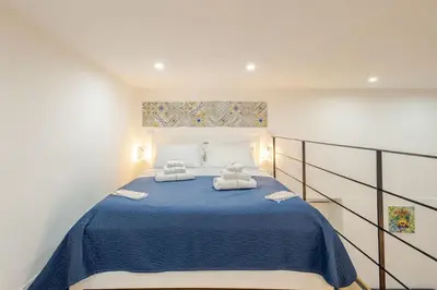 a bedroom with a blue bed with two towels at Palermo home cathedral apartment in Palermo