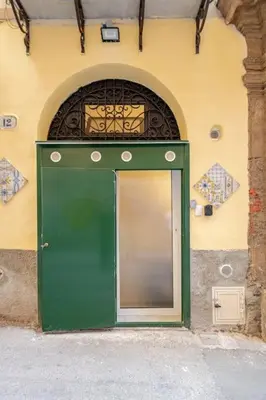 a green door on the side of a building at Palermo home cathedral apartment in Palermo