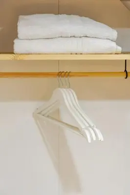 a towel rack with white towels on a shelf at Palermo home cathedral apartment in Palermo