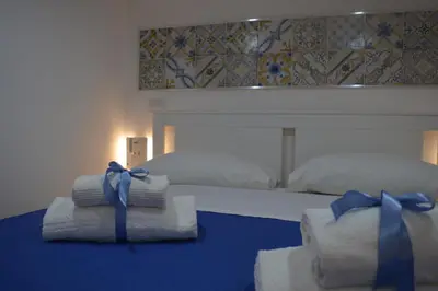 a bedroom with two towels with blue bows on them at Palermo home cathedral apartment in Palermo