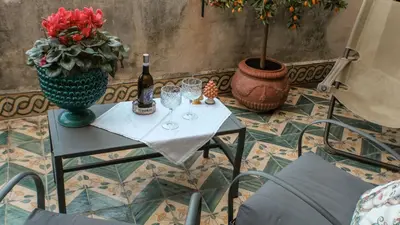 a table with wine glasses and a vase with flowers at Donna Guia suite in Palermo