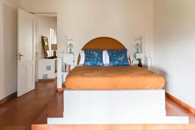 a bedroom with a large bed with blue pillows at Tenuta dei Principi di Spadafora in Bosco Fraccia