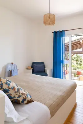 a bedroom with a bed and a blue chair at Tenuta dei Principi di Spadafora in Bosco Fraccia