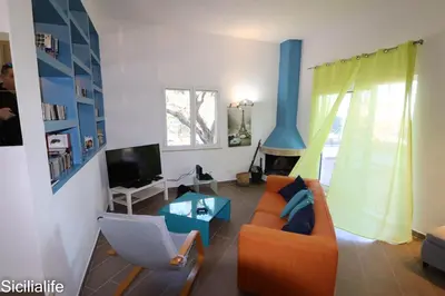 a living room with a orange couch and a tv at Villa Casa di Franca - 700 meters from the sea Scopello in Castellammare del Golfo