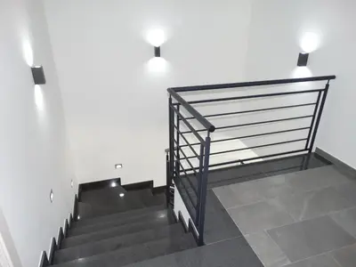 a set of stairs with a metal railing and a white wall at Villa Milicia - New Private Villa near Palermo and Cefalù with Pool, Sea View Terrace, Playground and Large Parking in Altavilla Milicia