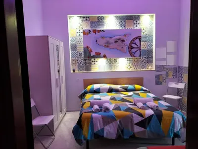 a purple bedroom with a bed with stuffed animals on it at La Loggia 34 in Palermo